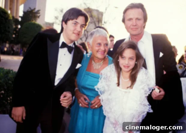 Angelina Jolie's Cinematic Journey: From Action Heroine to Dark Queen and Beyond 2 Angelina Jolie and family at the 1986 Academy Awards, showcasing her early public appearance and developing style.