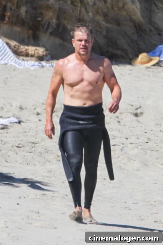 Gavin Rossdale, 54, Defies Age Shirtless On The Beach – Plus 23 More Over-45 Stars With Jaw-Dropping Summer Bodies 3 Matt Damon walking on the beach in a wetsuit, showing his fit build.