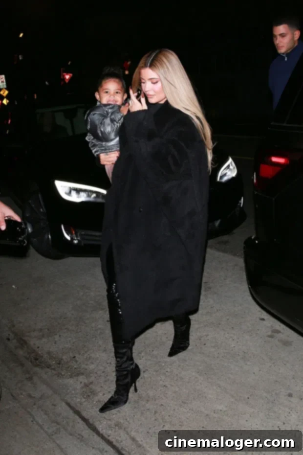Kylie Jenner carrying Stormi Webster as they step out together in Santa Monica, both exuding coordinated style.