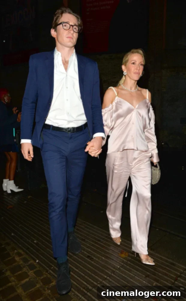 Ellie Goulding and Caspar Jopling, new parents, walking hand in hand at an event.