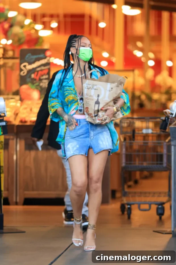 Rihanna's Everyday Glam: Groceries, Braids, Mini Skirt 2 Rihanna grocery shopping at Bristol Farms in Beverly Hills, wearing a denim mini skirt and colorful top.