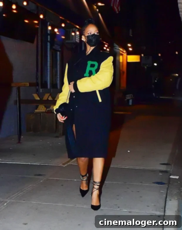 Rihanna steps out in NY for dinner with beau A$AP Rocky, wearing an oversized letterman style coat with a green 'R'.