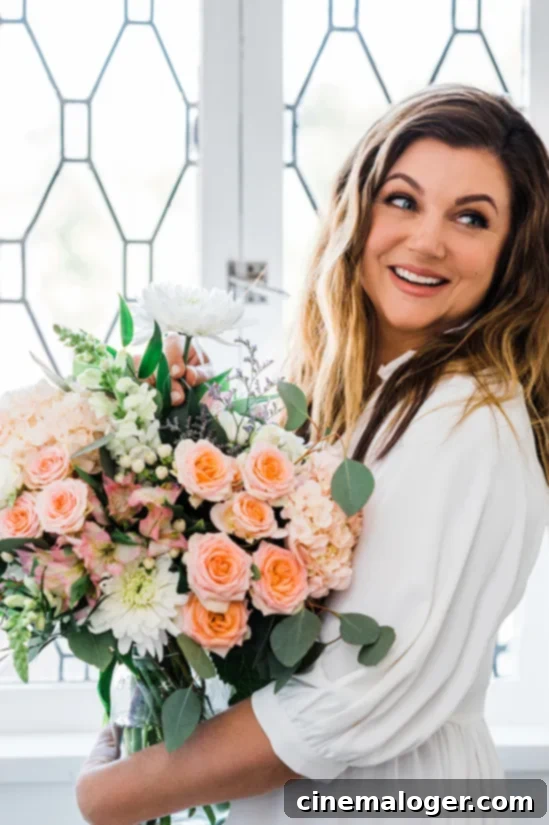 Tiffani Thiessen Reveals Her Single Request for Rob Dyrdek and Deliciousness Hosting Role 3 Tiffani Thiessen holding a vibrant bouquet of flowers, smiling warmly.