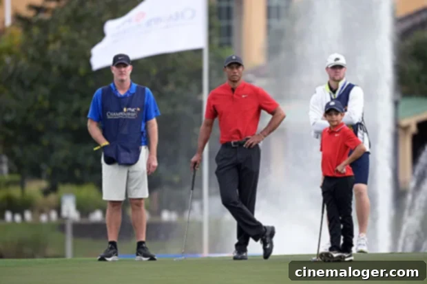 New Series Reveals Tiger Woods' Emotional Reaction To Son Charlie, 12, Playing Golf 3 Tiger Woods and son Charlie walking on a golf course during a tournament, both wearing purple shirts
