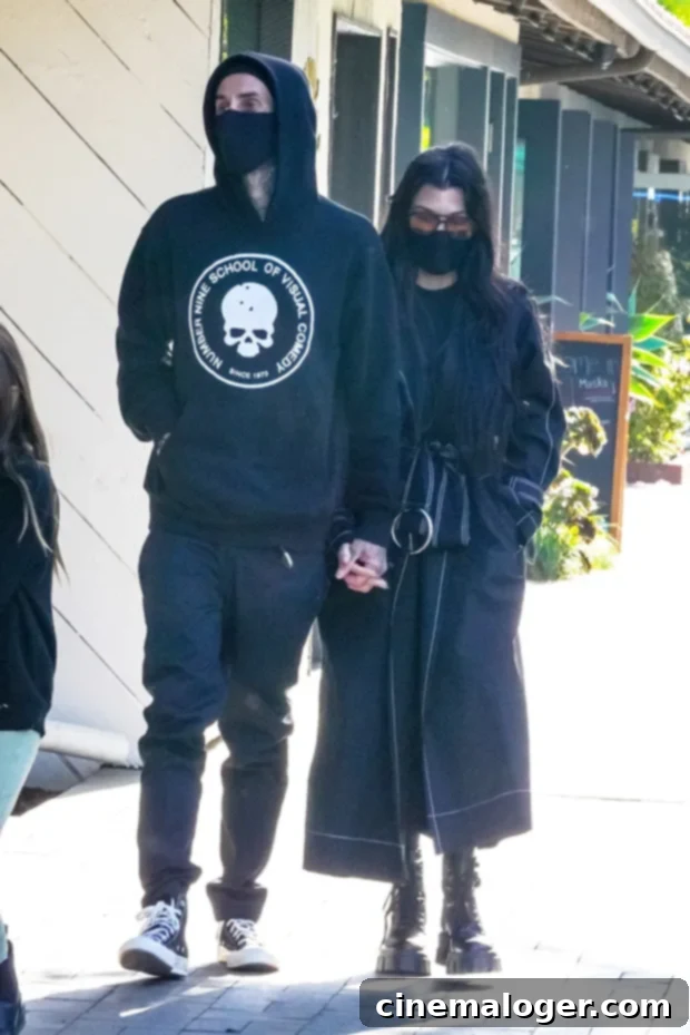 Kourtney Kardashian Unlocks Travis Barkers Healing After Crash 2 Travis Barker and Kourtney Kardashian walking with Penelope.