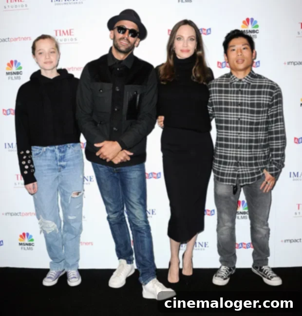 Shiloh Jolie-Pitt, 15, Stuns in Ripped Denim, Mirrors Angelina's Chic Presence at Premiere with Family 2 Angelina Jolie with Pax and Shiloh at JR's Paper & Glue documentary premiere, looking stylish and supportive.