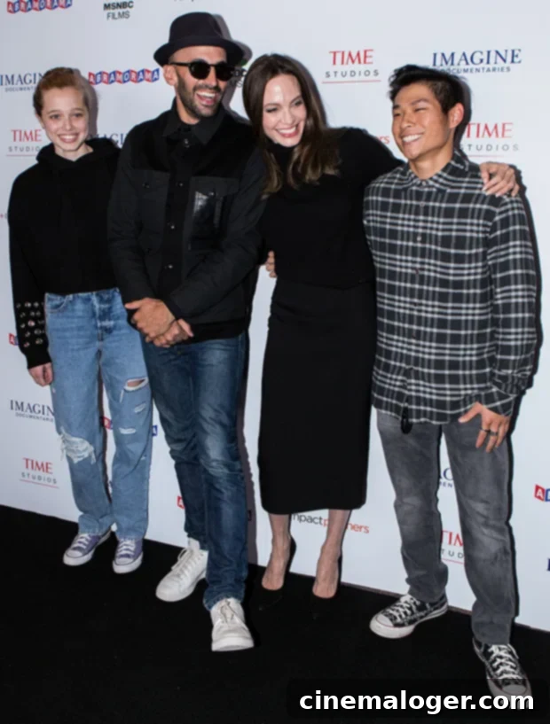 Shiloh Jolie-Pitt, 15, Stuns in Ripped Denim, Mirrors Angelina's Chic Presence at Premiere with Family 3 Shiloh Jolie-Pitt confidently poses with JR, Angelina Jolie, and Pax Jolie-Pitt on the red carpet.
