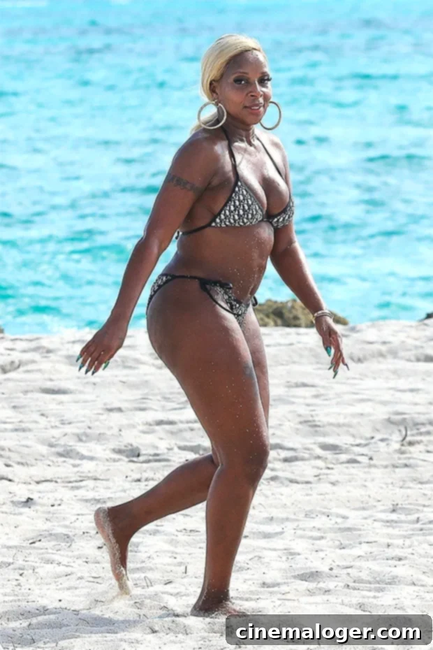 Mary J. Blige in a black and white Dior bikini on Miami beach, showing her style and confidence.