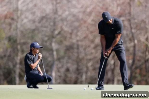 Tiger Woods putts as his son Charlie Woods watches during a golf warm-up.