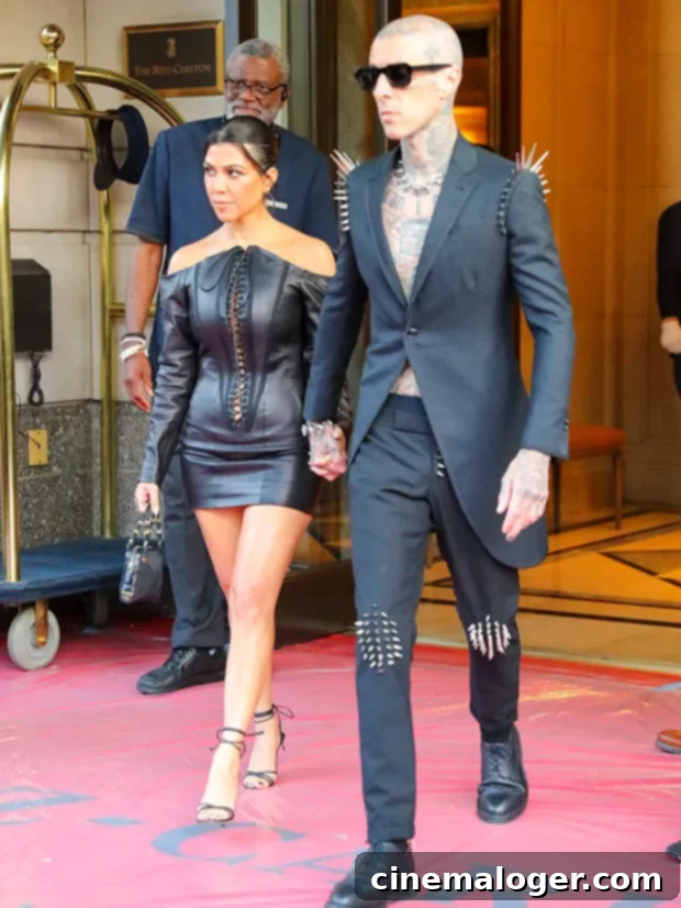 Kourtney Kardashian Rocks The Drums Like Travis Barker In Studio 2 Kourtney Kardashian and Travis Barker holding hands, Kourtney wearing a band t-shirt.