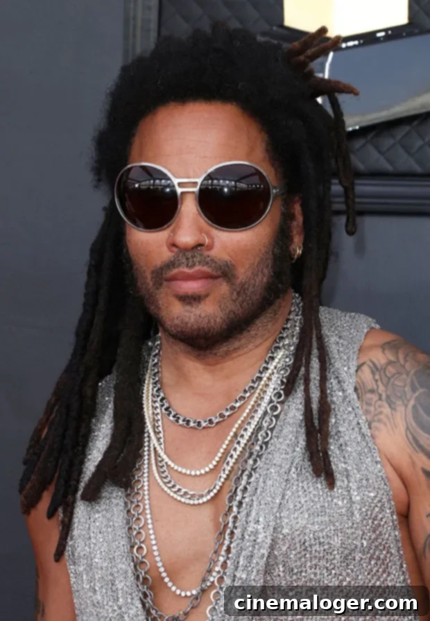 Lenny Kravitz Sparkles in Mesh Tank and Towering Heels at the Grammys 3 Lenny Kravitz with his signature dreadlocks and large sunglasses at the 2022 Grammys red carpet.