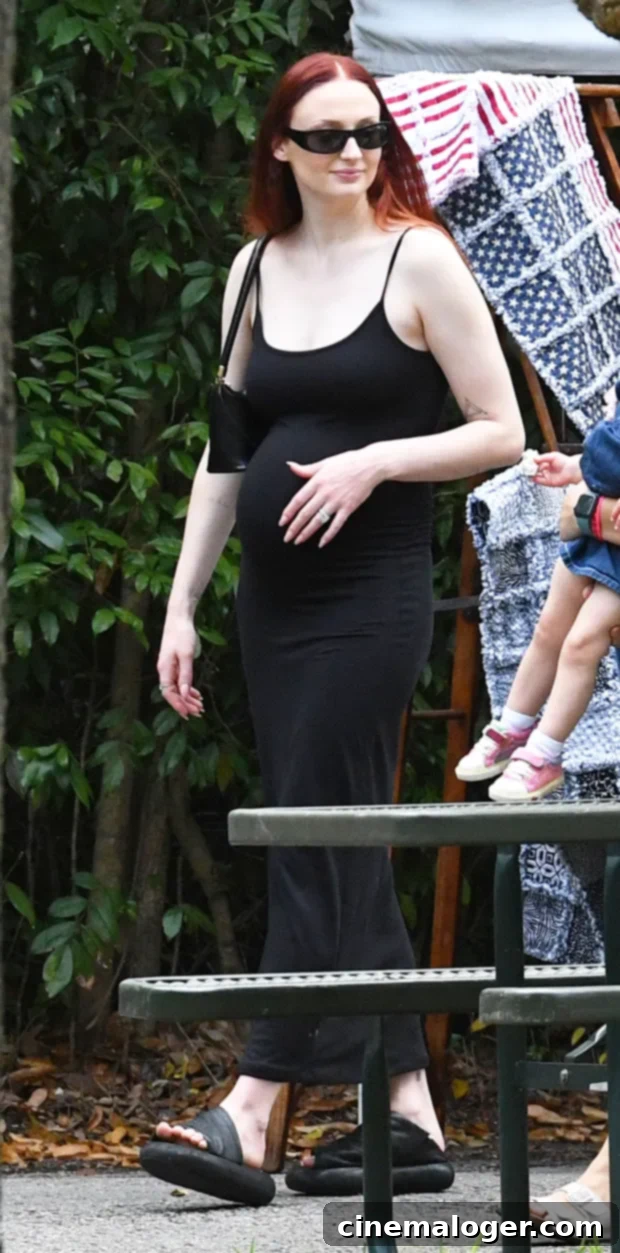 Sophie Turner's Baby Bump Bliss: A Tender Outing with Joe Jonas 3 Sophie Turner pregnant in a black dress, holding her baby bump.