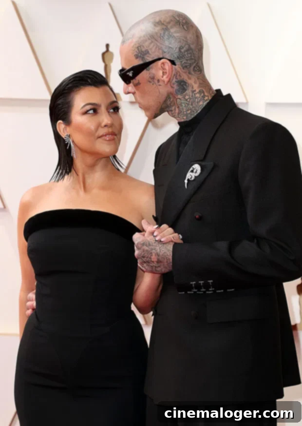 Travis Barker's Name Sparkles on Kourtney Kardashian's Diamond Ring 2 Kourtney Kardashian and Travis Barker on the red carpet at the Academy Awards 2022, showcasing their unique style as a couple.