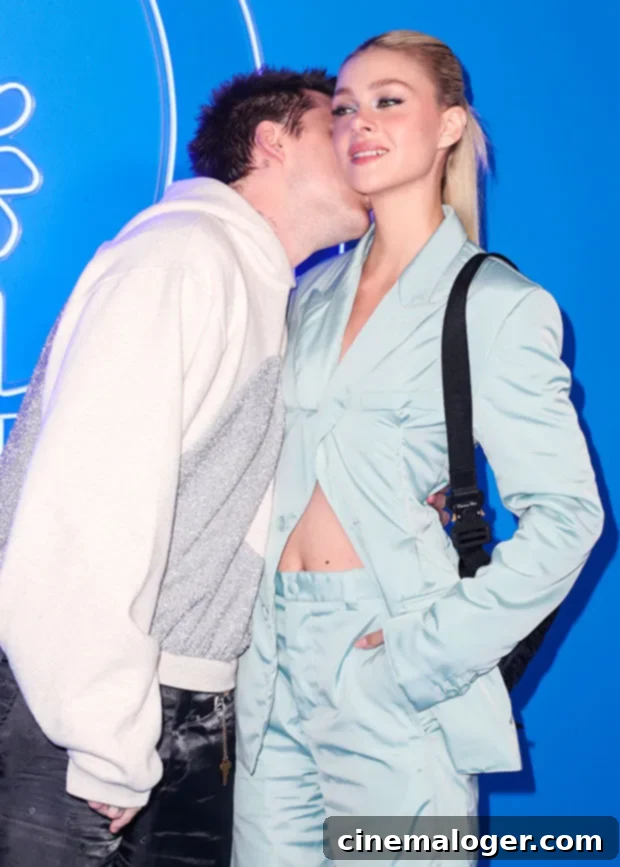 Brooklyn Beckham and Nicola Peltz's Loved-Up Dior Red Carpet PDA 3 Brooklyn Beckham affectionately kisses Nicola Peltz Beckham on the neck, a sweet public display of affection at the Dior fashion event.