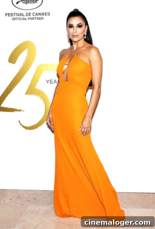 Eva Longoria Captivates Cannes amfAR in a Daring High-Slit Gown 3 Eva Longoria in a vibrant orange dress at a Cannes Film Festival party
