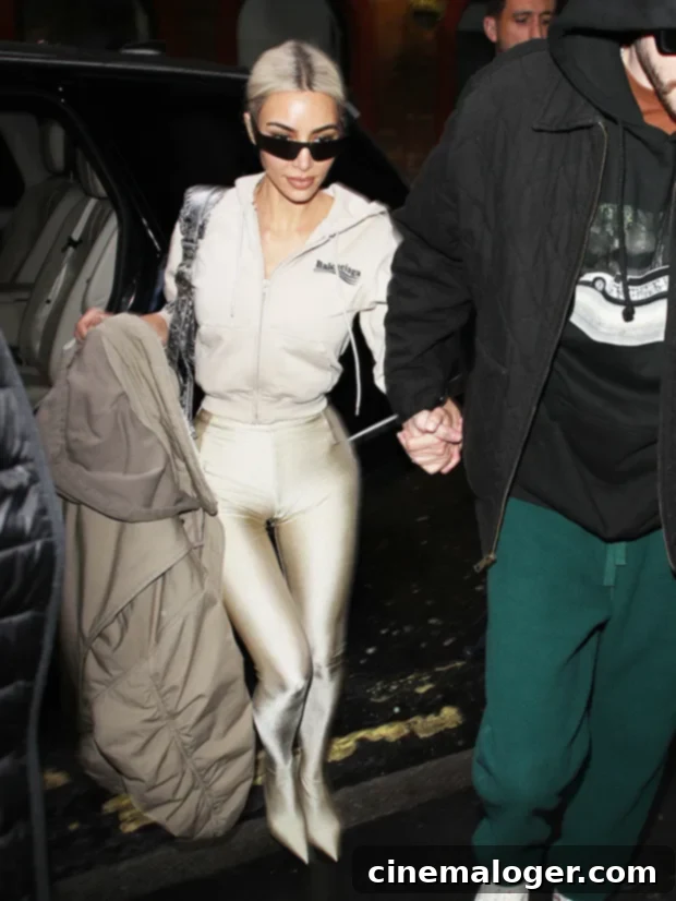 Kim Kardashian's Balenciaga Pants: Three Days Different Hues 4 Kim Kardashian in a tan Balenciaga Pantashoes outfit with a cropped hoodie, Le Cagole bag, and sunglasses.