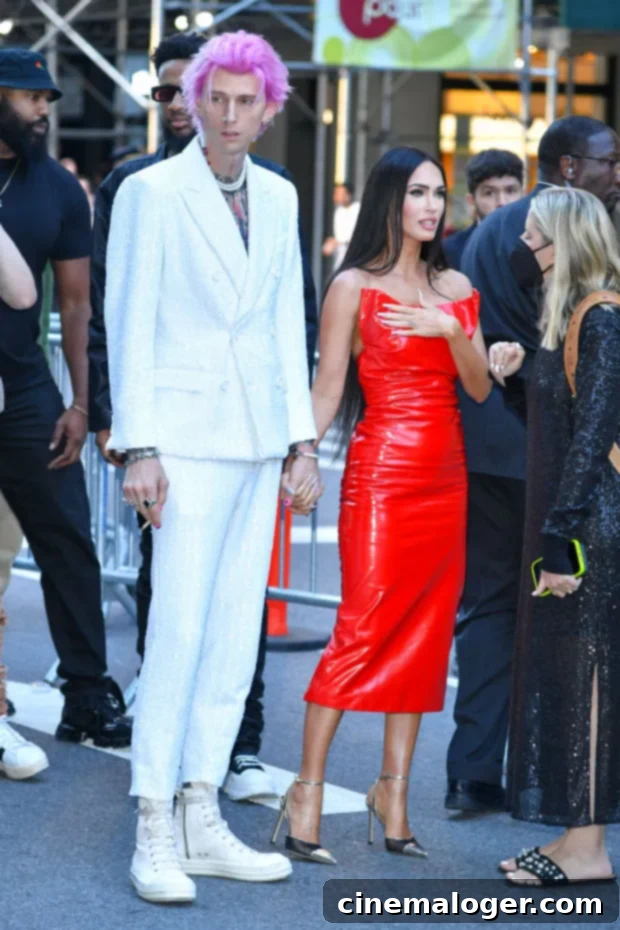 MGK's Shocking Admission: Almost Shot Himself on Call With Megan Fox 2 Machine Gun Kelly looking at the camera with a serious expression, wearing a black shirt and chains.