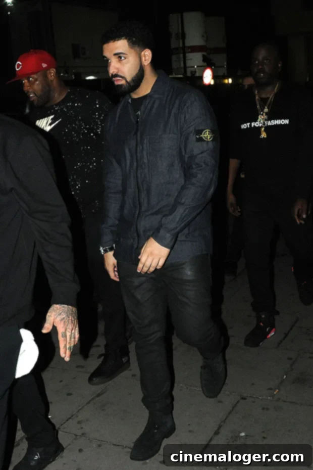 Drake's Bold New Look A Mother's Name Etched on His Face 2 Drake, the renowned rapper and music artist, captured in a promotional or live performance image.