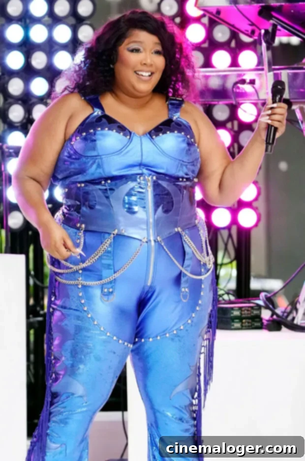 Lizzo Confidently Rocks Sheer Pink Jumpsuit with Pastel Thong in Sizzling New Video 2 Lizzo on stage in a blue lame jumpsuit