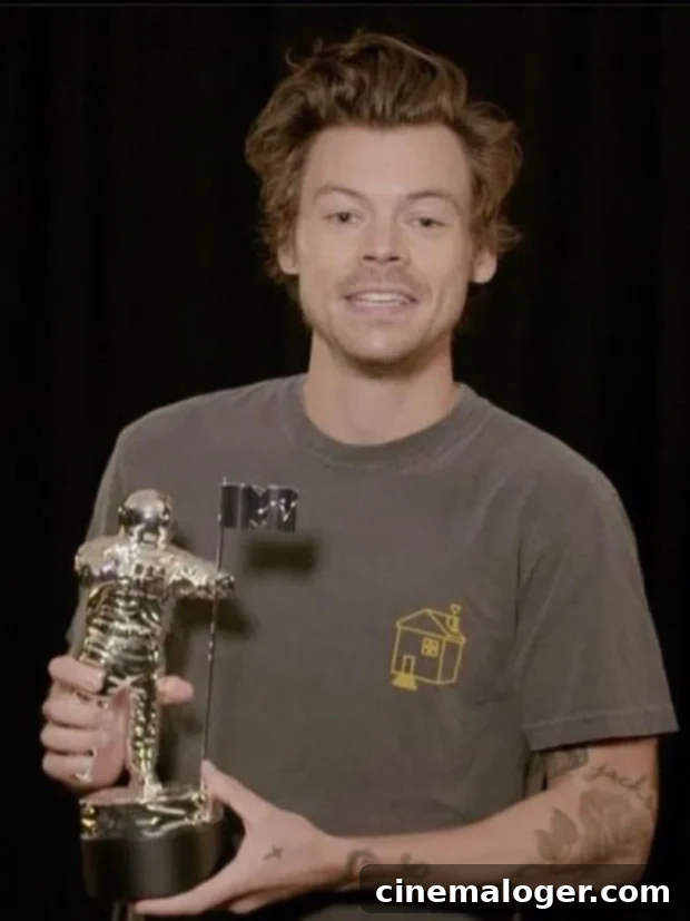 Harry Styles Takes Home VMA Album Of The Year, Apologizes For Missing The Show 2 Harry Styles accepts the MTV VMA for Album of the Year in a video message, wearing a grey t-shirt.