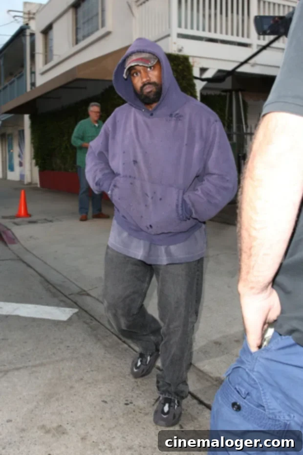 Kanye West Rocks Distressed Purple Hoodie For Santa Monica Dinner 2 Kanye West seen wearing a purple ripped hoodie and hat in Santa Monica, California, in August 2022, after leaving Giorgio Baldi restaurant.