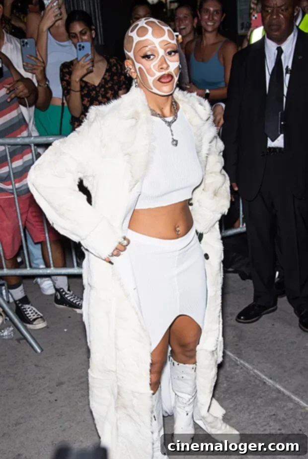 Doja Cat's White Paint Masterpiece Steals NYFW Spotlight 2 Doja Cat at Vogue World: New York Fashion Week with cow-print inspired shaved head and white face paint.