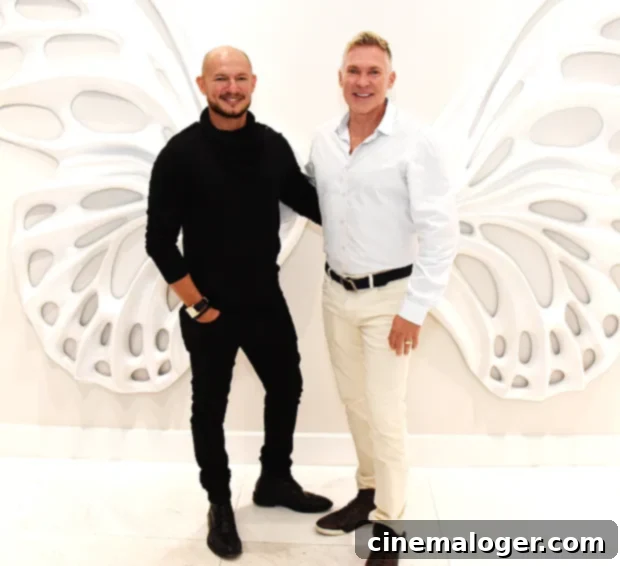 Sam Champion (R) and his husband, Rubem Robierb (L), at an art show in 2019, smiling warmly.