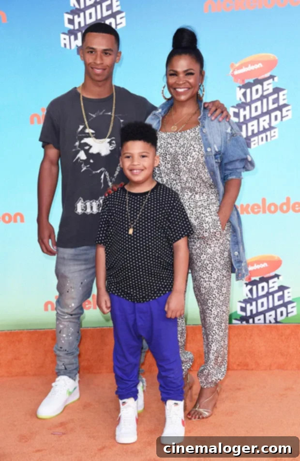 Meet Nia Long's Two Children, Including Her Son With Ime Udoka 2 Nia Long smiling, holding hands with her two sons, Massai Dorsey II and Kez Sunday Udoka, who are also smiling.