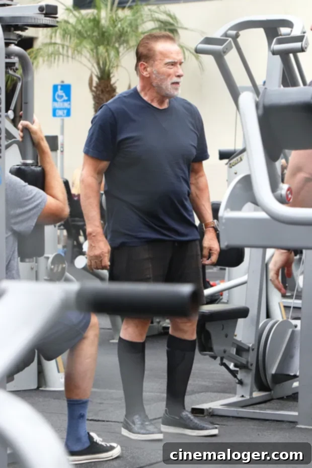 Joseph Baena Pumps Iron With Dad Arnold Schwarzenegger, Strengthening Family Ties Amidst DWTS Demands 3 Joseph Baena and Arnold Schwarzenegger engaging in conversation during their gym session.