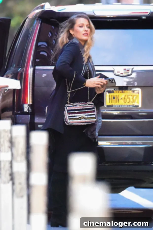 Blake Lively's Manhattan Maternity Chic 2 Blake Lively walks in New York City in November 2022, showing off her baby bump in a stylish black outfit with knee-high boots and a striped Chanel bag.