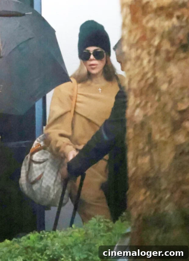 Kim Kardashian and Khloe Console Grieving Tristan Thompson After Mother's Passing 2 Khloe Kardashian looking somber and thoughtful, dressed in a beige outfit with a black beanie and sunglasses, departing Toronto after the passing of Tristan Thompson's mother.