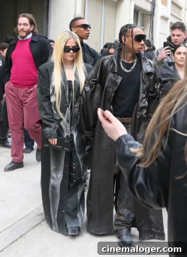 Avril Lavigne and Tyga Step Out in Matching Leather, Confirming PFW Romance 2 Avril Lavigne and Tyga making a striking appearance in matching black leather at the Y/Project show during Paris Fashion Week, showcasing their unified style.