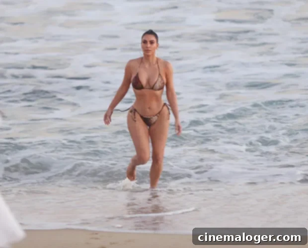 Kim Kardashian's SKIMS Nude Beach Sensation 3 Kim Kardashian splashing in ocean water during a beach photoshoot, showcasing a confident and playful side.