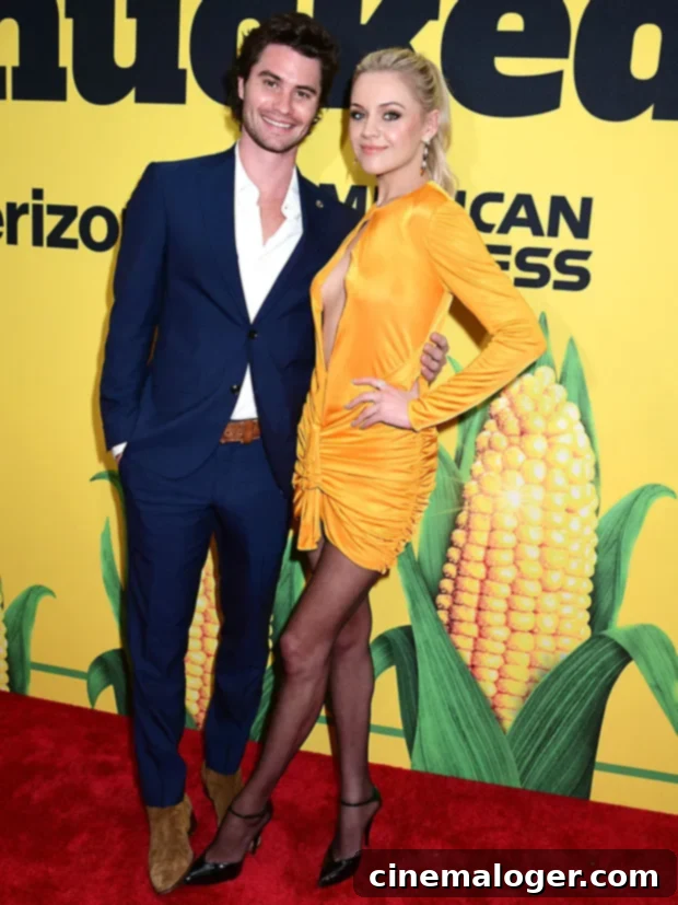 Kelsea Ballerini and Chase Stokes Confirm Romance at Shucked Premiere 3 Kelsea Ballerini and Chase Stokes looking at each other and smiling on the Shucked red carpet. Kelsea is in a yellow dress and Chase in a navy suit.