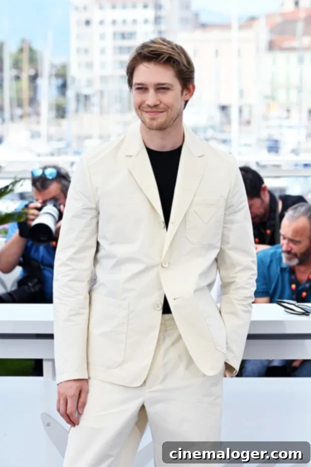Joe Alwyn Makes First Major Public Appearance At Cannes Since Taylor Swift Split 2 Joe Alwyn looking dapper in a silky black suit with a peach-colored button-up shirt and sunglasses at the Celine dinner party in Cannes.
