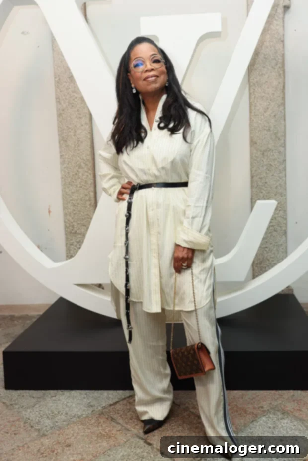 Oprah, 69, Stuns at Louis Vuitton Show After Major Weight Loss 2 Oprah Winfrey at Louis Vuitton Cruise Show, showcasing weight loss in a belted striped dress and pants.