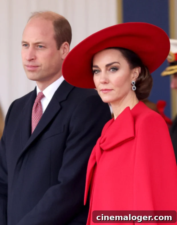 Prince William stands formally, dressed in a suit, against a blurred background, possibly at a royal event.