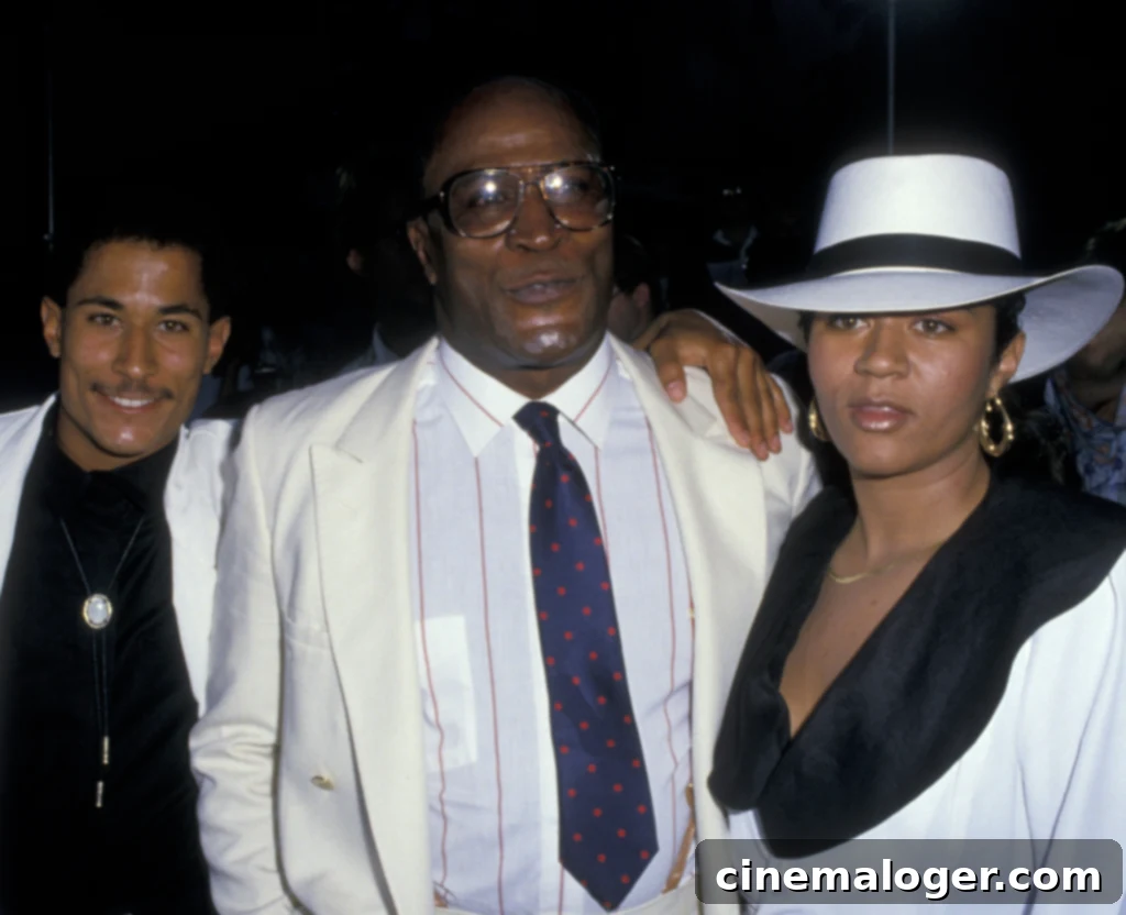 John Amos' Death Revealed: What Happened to the Roots and Good Times Icon 3 John Amos, wife Noel Amos and son Kelly Amos attend the premiere of "Coming To America" on June 26, 1988 at Mann Chinese Theater in Hollywood, California. (Photo by Ron Galella, Ltd./Ron Galella Collection via Getty Images)
