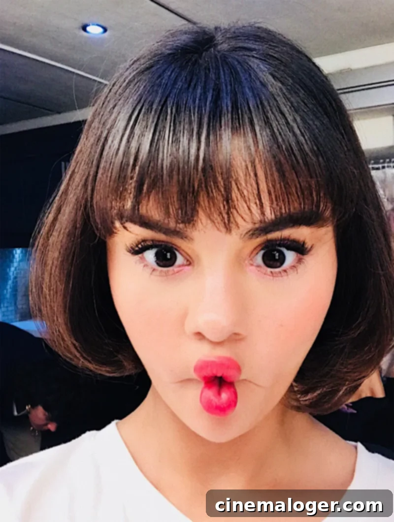 Selena Gomez in a close-up shot, flaunting her new short brunette hair and enhanced lips.