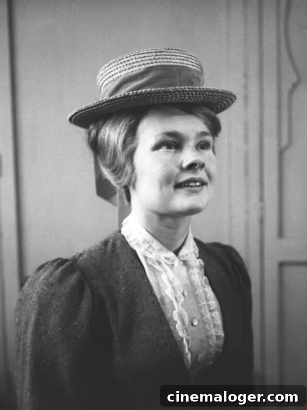 Judi Dench smiling confidently, wearing an elegant blue outfit